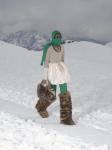 Новая коллекция Miu Miu осень-зима 2021/22, которую Миучча Прада (Miuccia Prada Bianchi) презентовала в условия заснеженных гор в Доломитовых Альпах, стала предложением сочетания казалось бы несочетаемых элементов одежды. Так, объемные лыжные костюмы, выполненные из пыльно-пастельного будуарного атласа, свитера в стиле «после катания» (apres-ski), вязаные балаклавы, которые также послужили масками для лица, легко совмещались с гламурными и вечерними нарядами.